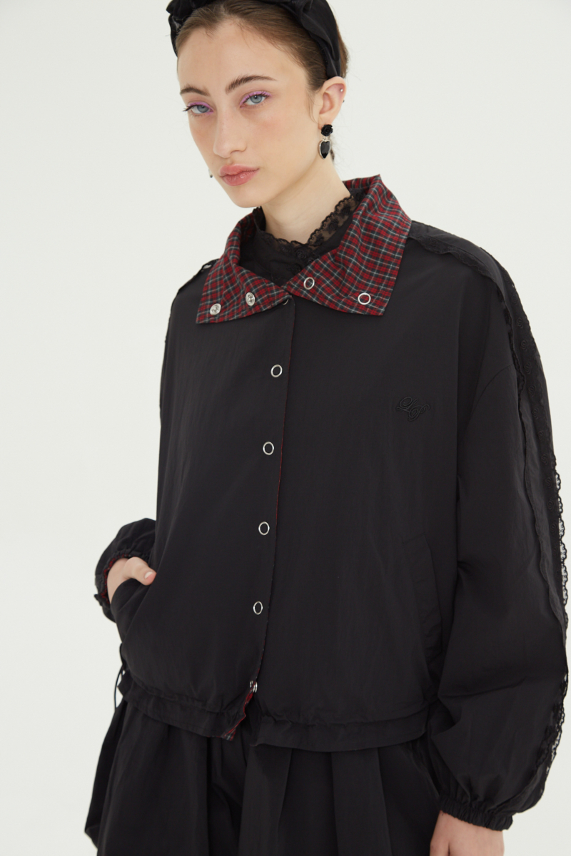 Campera reversible con puntilla y motivo de cuadros, cuello alto, broches snap y cintura con tancas. 
