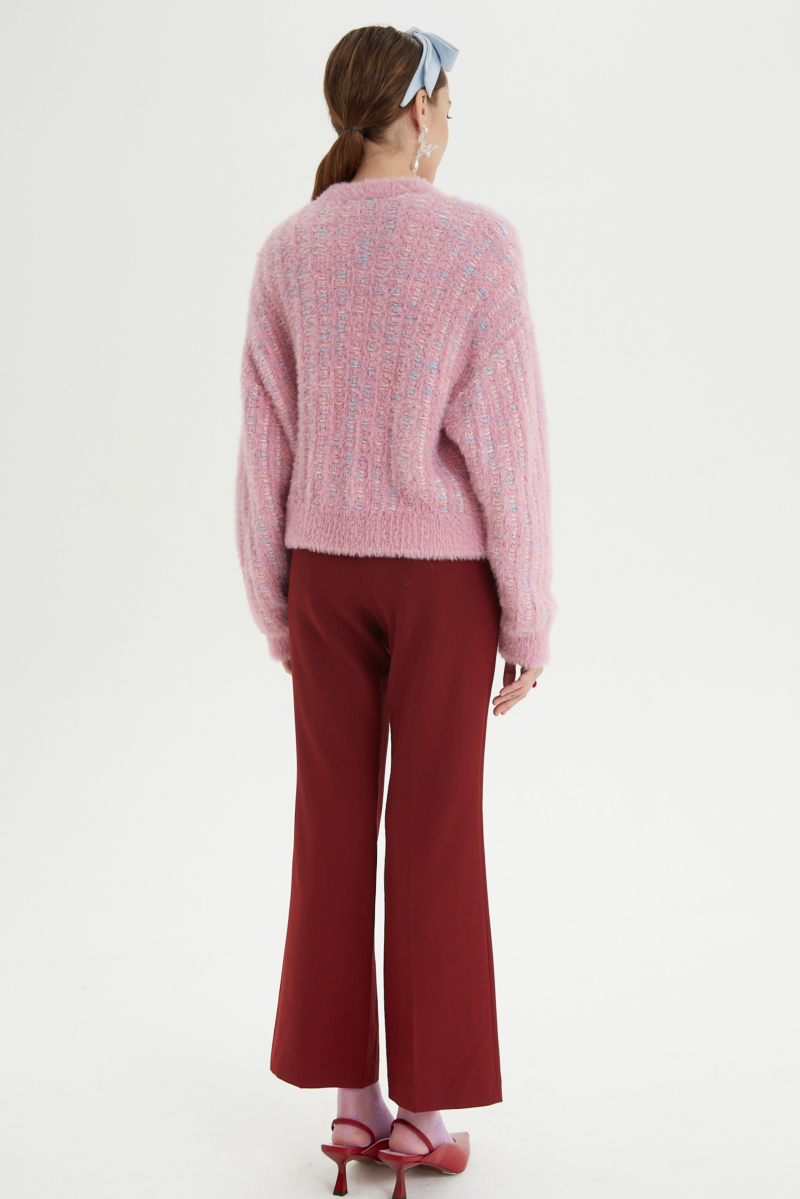 Saco tejido multicolor con textura de pelo y botones perlados en forma de flor. 
