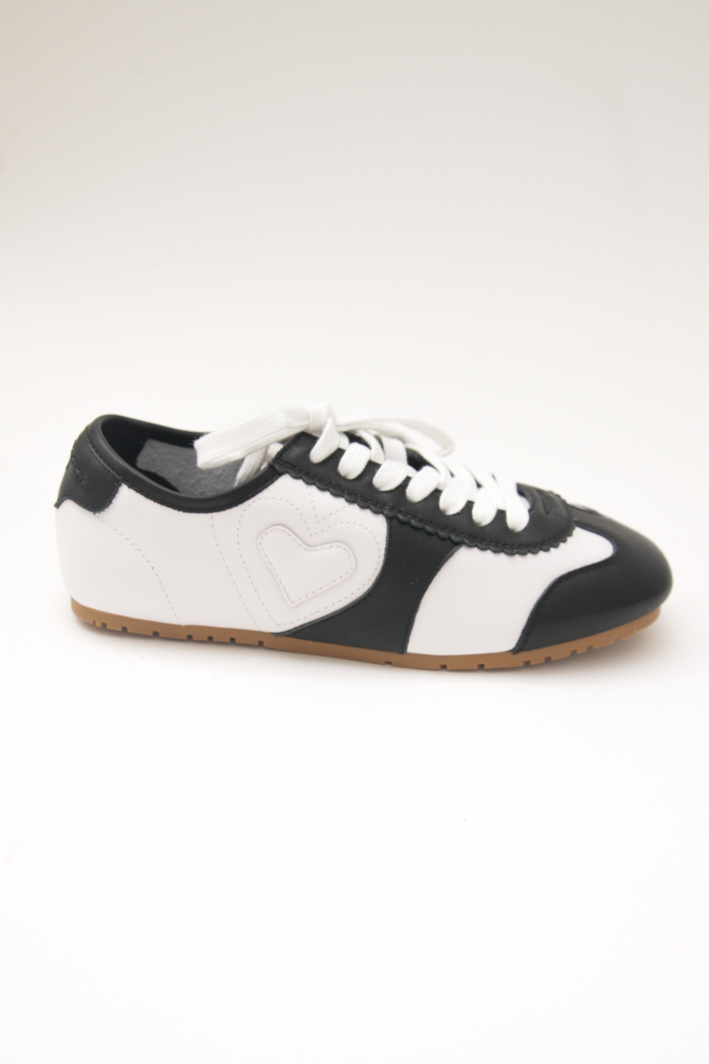 Zapatillas blanca y negra de cuero con recortes, punta cuadrada y suela de caucho.