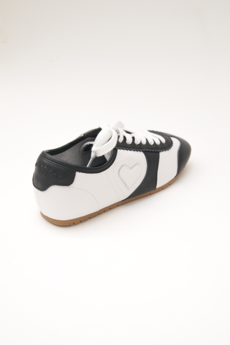 Zapatillas blanca y negra de cuero con recortes, punta cuadrada y suela de caucho.